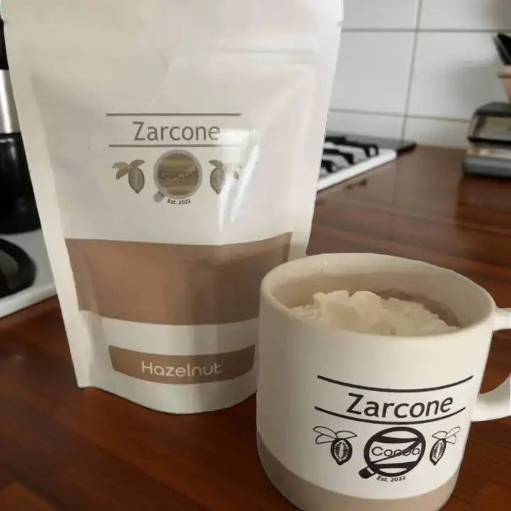 Zarcone Cocoa Hazelnut Cocoa package and a mug with coffee on a kitchen counter.