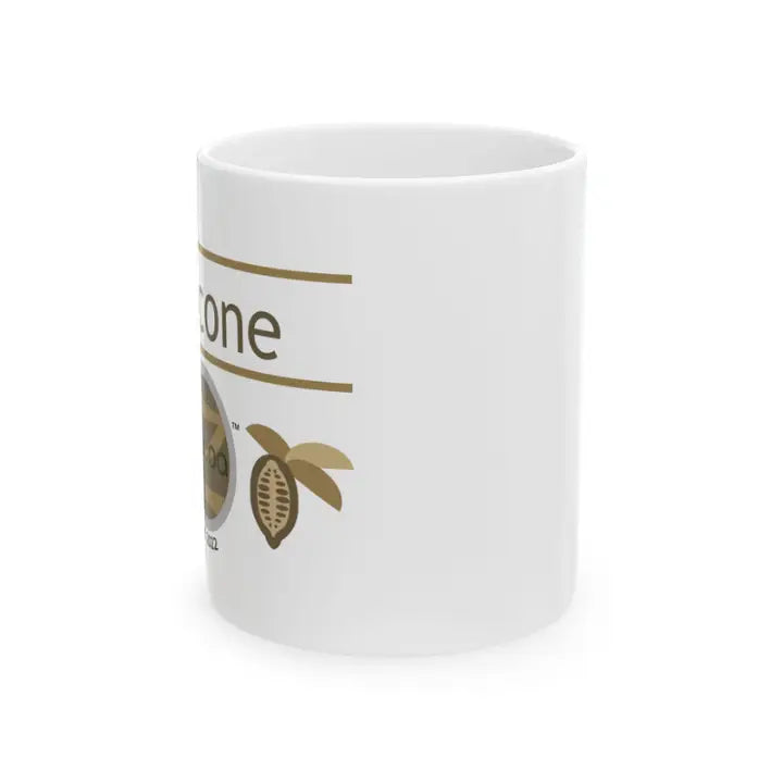 White mug with gold text and cocoa bean illustration on a white background